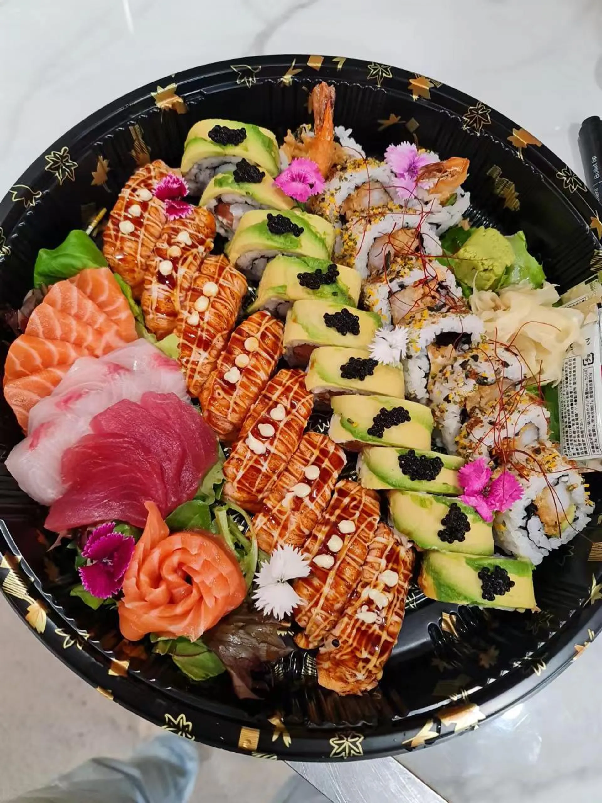 Elaborate sushi party platter with dragon rolls, aburi tuna, avocado caviar rolls and sashimi