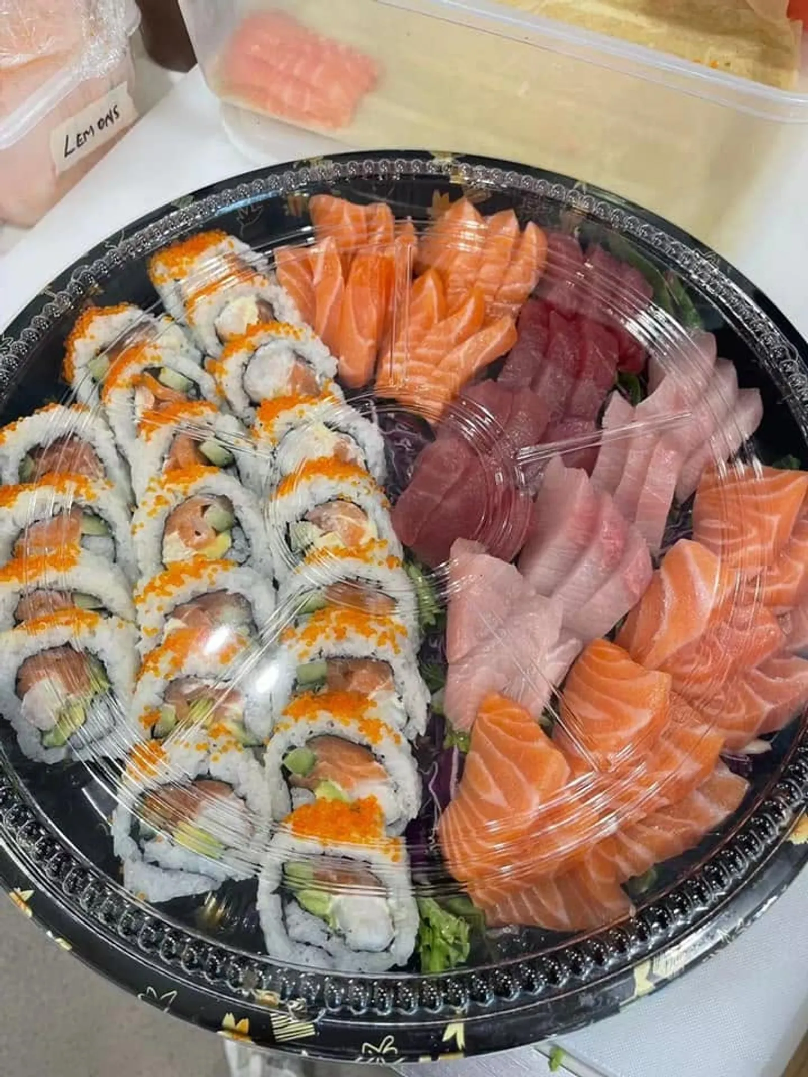 Large sushi and sashimi party platter with salmon rolls, tuna and salmon sashimi